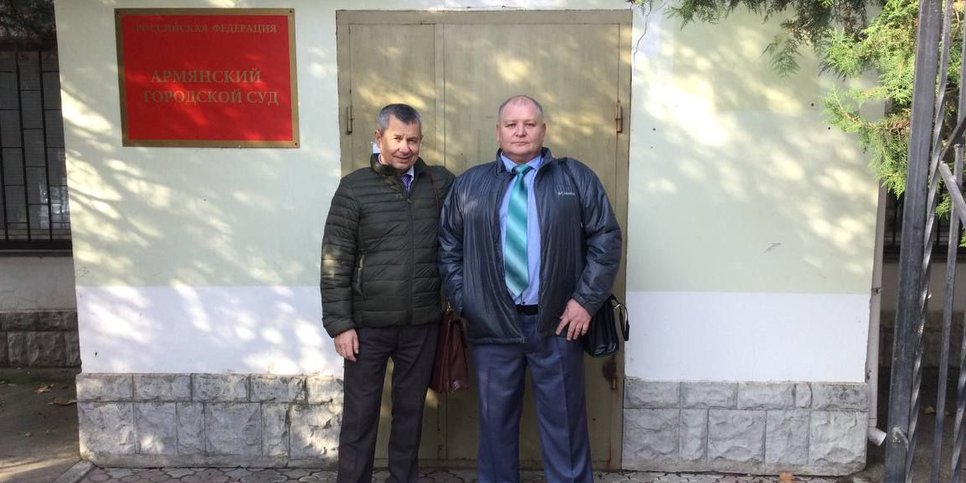 Alexandr Litvinyuk e Alexandr Dubovenko perto do edifício do tribunal