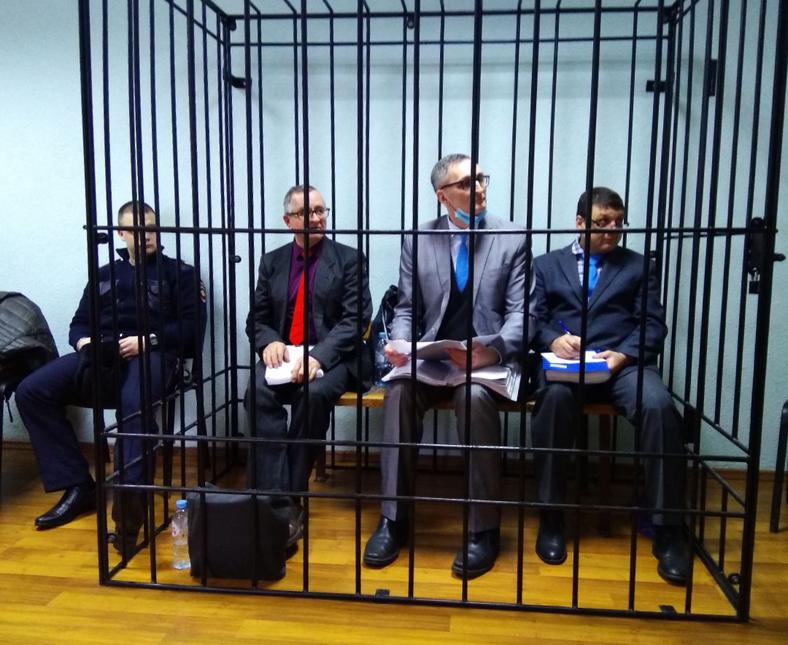 Vladimir Piskaryov, Vladimir Melnik e Artur Putintsev foram mantidos em uma jaula durante seu julgamento em Oryol