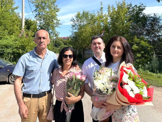 Da esquerda para a direita: O pai e a irmã de Sona, junto com o marido, posam para uma foto com ela após sua libertação. Julho de 2025